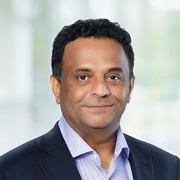 Shreeram Aradhye, President, Global Drug Development and Chief Medical Officer for Novartis pictured in front of a green, blurred background.