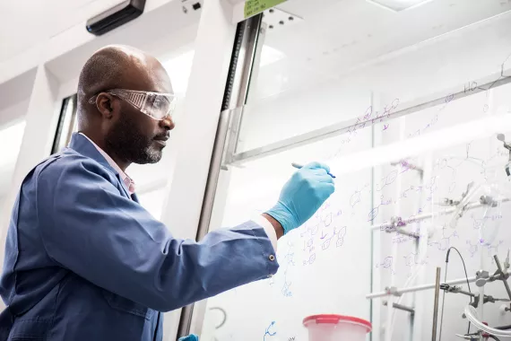 Scientist writing on a glass wall