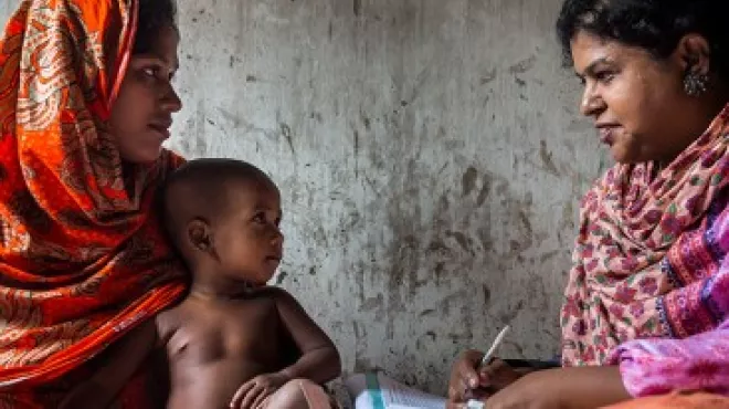 A mother and child in Bangladesh are interviewed by a nurse