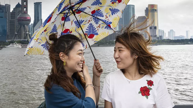 Chinese girls sharing umbrella